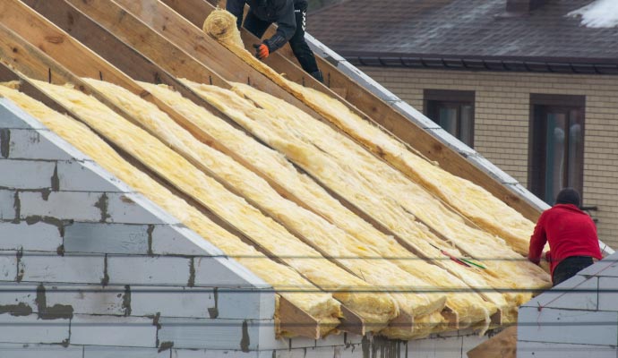 Roofing insulation services Person installing roof insulation