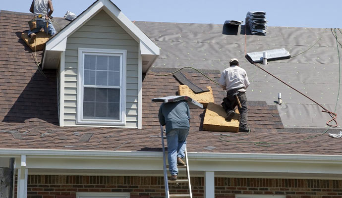 A group of professionals performing maintenance on a roof